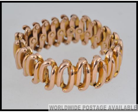 A designer yellow metal articulated expanding bracelet (tests for 9ct) with expanding links marked Baden, 9, S and patent. We