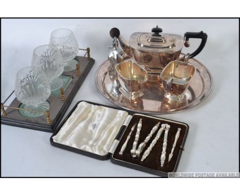 A collection of silver plated items to include part tea service and tray, a cased set of nut crackers and a drinking glass se