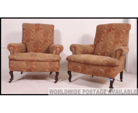 A Victorian Chesterfield Drop Arm Sofa raised on turned supports together with a pair of matching Chesterfield armchairs. All