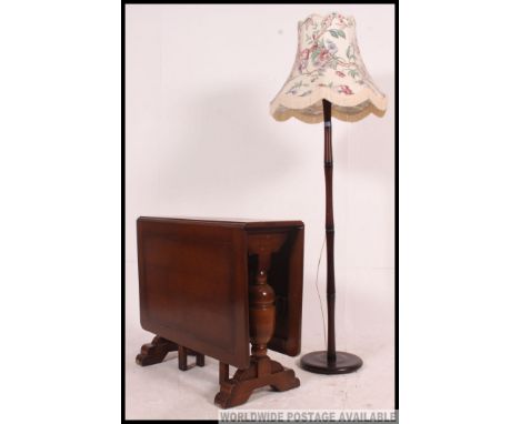 A 1930's drop leaf dining table together with a mahogany standard lamp with shade on circular terraced base