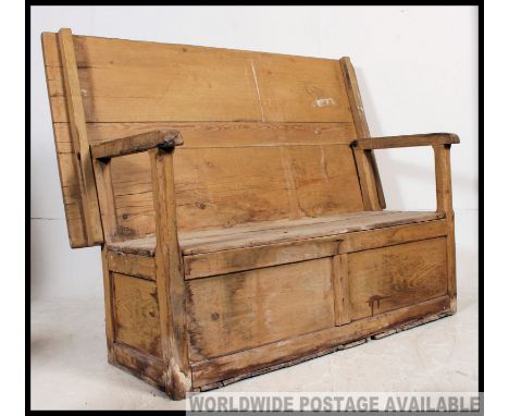 A large Victorian country pine monks bench settle / table. Of large form with planked chest under seat with hinged and swivel