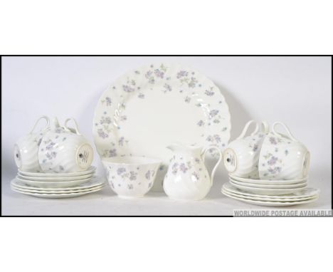 A chintzy bone china tea service from Wedgwood in the ' April Flowers ' service, consisting of six trios, creamer, sugar bowl