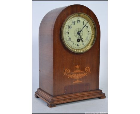 An Edwardian mahogany inlaid dome top mantel clock with decorative face with brass movement