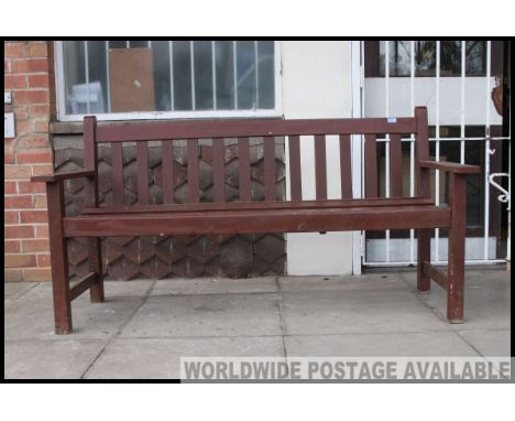 A 20th century wooden garden bench with slatted seat  and back rest with elbow supports. All on squared legs