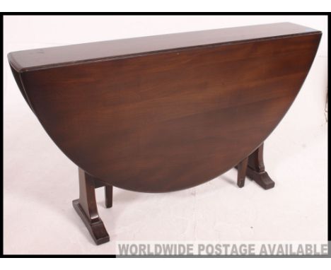 A 20th century large Ercol drop leaf dining table. The thin centre with full length half moon drop leaves either side support