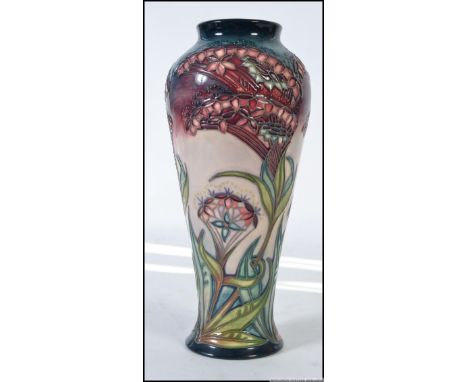 An contemporary Moorcroft of England. A ceramic baluster shape tube lined vase, having marks to base for William John Moorcro