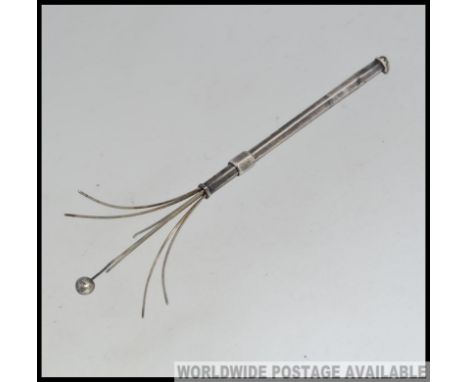 An early 20th century silver telescopic cocktail twizzle stick with extending end. marked silver