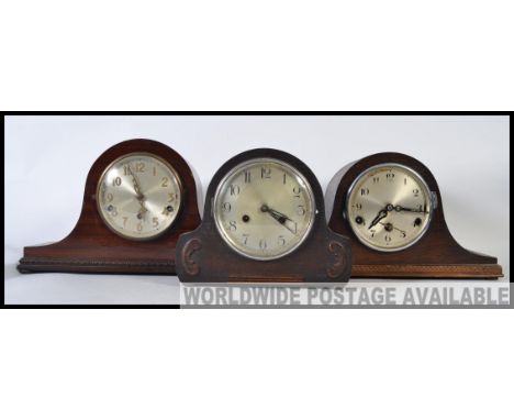 A collection of three mid century mantel clocks having napoleons hat examples with silvered dials, brass movements within