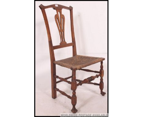 A 19th century country oak and rush seated nursing chair. Raised on turned legs with pad feet united by stretchers having rus