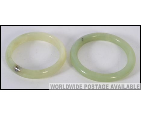 An Apple Green Jade Bracelet together with a bright green jade bangle of similar form
