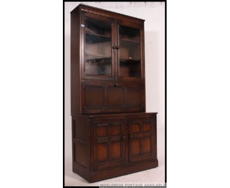 An Ercol upright colonial beech and elm dresser / cabinet. The base with cupboards having upright body with fall front centre