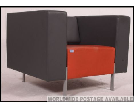 A great vintage retro orange and grey vinyl armchair on powder coated metal legs, with a wedge shaped back rest.  By Kinnarps