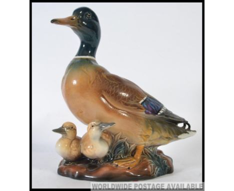 A fabulous life sized ceramic figure group of a Drake Mallard with his young, set on a naturalistic base and stamped to the b