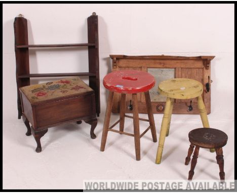 A collection of vintage milking parlour stools together with a wall mounted coat rack, show box and open window oak bookcase