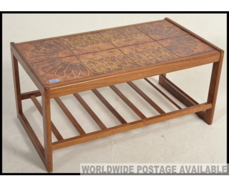 A late 20th Century rectangular  teak coffee table with inset fat lava style tiled top, raised on square legs united by under