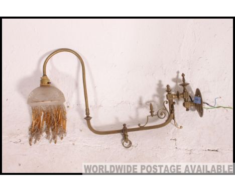A long armed and decorative brass side wall lamp. 19th century with cut glass shade and beading.