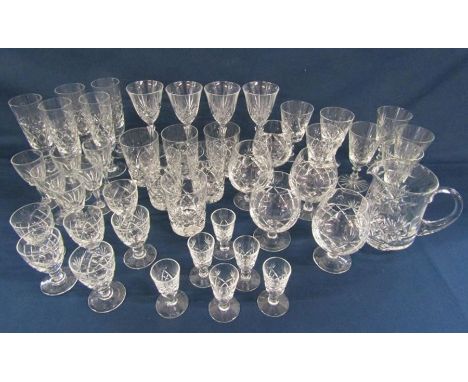 Collection of crystal glass ware includes brandy glasses, tumblers, flutes and a water jug