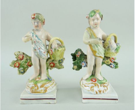 A RARE PAIR OF SWANSEA CAMBRIAN POTTERY PUTTI in the form of swag wearing flower pickers and their baskets and with single fl