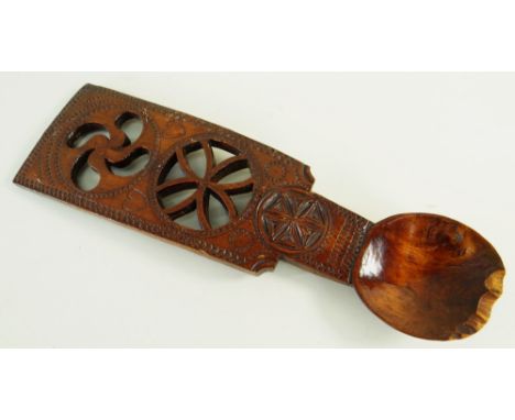 19TH CENTURY SYCAMORE CARVED LOVE-SPOON decorated with pierced treskelion motif over a pierced flower-head over a smaller geo