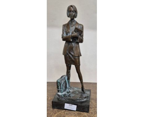 A bronze figure of a female office worker on black marble socle 