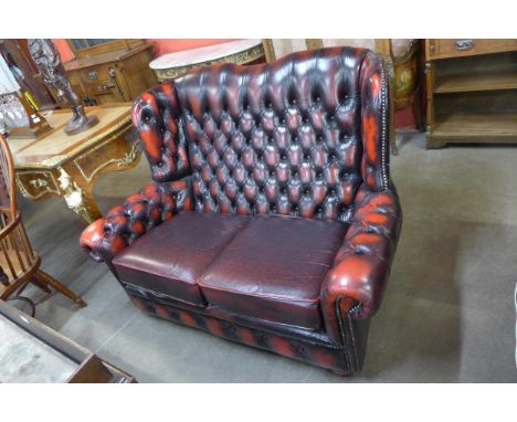 An oxblood red leather Chesterfield wingback sofa 