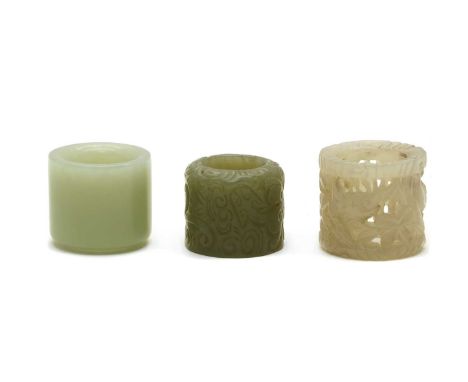 A collection of three Chinese jade archers rings, comprising: one pierced and carved with deer and foliage, 3.2cm high, one c