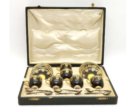 A Royal Worcester cased set of six demitasse coffee cups, with gilt decoration to a black ground, gilt interiors and handles,