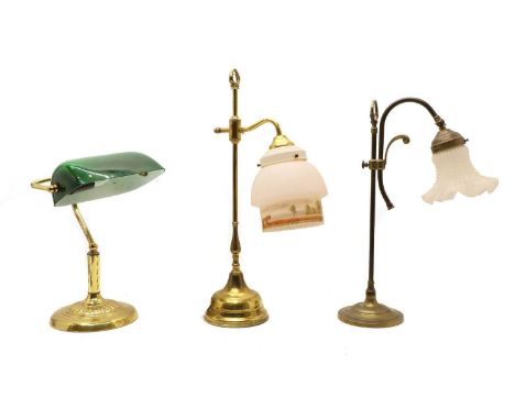 Three brass desk lamps, the first with green glass shade, the other two with adjustable heights and glass shades.Condition re