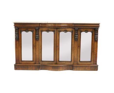 A Victorian rosewood buffet, of rectangular form, in three sections, with four doors opening onto internal shelving, the door