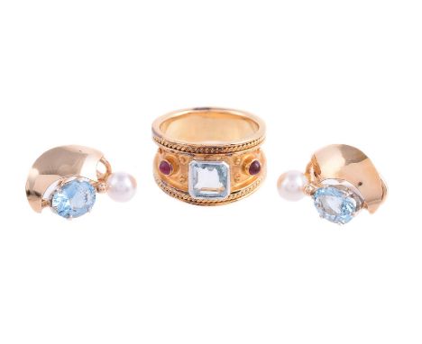 
	
		AN AQUAMARINE AND RUBY DRESS RING
		The broad ring with a central step cut aquamarine with canted corners, set between t