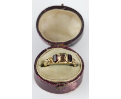 A Georgian Foil Backed Garnet and Citrine? Three Stone Ring in an unmarked high carat gold setting with foliate chased should