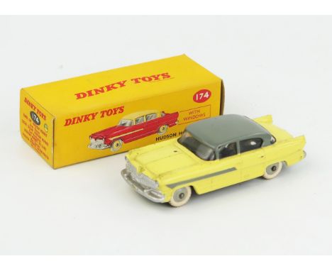 A Dinky Toys 174 Hudson Hornet Sedan with light yellow lower body, grey roof, flash and hubs, white tyres in correct type 1 p