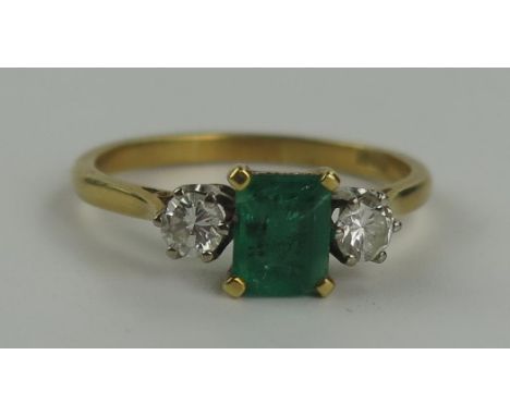 18ct Gold, Emerald and Diamond Three Stone Ring, the central 6.5x5mm stone flanked by 3.5mm diamonds, size P.5, 3.1g 