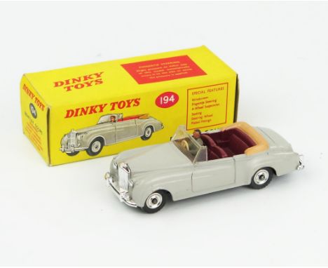 A Dinky Toys 194 Bentley S2 Coupe in grey with maroon interior, tan hood, grey male driver, spun hubs and gloss black base. N