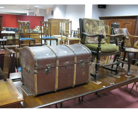 An Early XX Century Domed Top Trunk, with leather handles; together with a 1920's oak elbow chair, with shaped arms, on turne