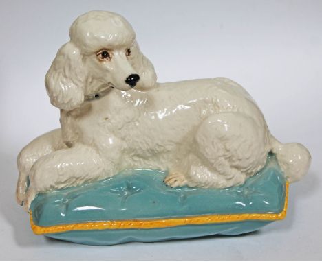 A Beswick poodle on cushion, length 17.5cm. CONDITION REPORT - good, no damage/repair, general wear only.