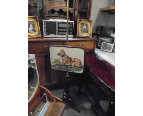 A Victorian mahogany pole screen with a tapestry panel featuring a dog. 