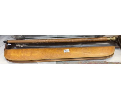 A The Wiltshire Brewery Company Old Devil cue, 1 other and a brass top walking stick snooker/pool cue