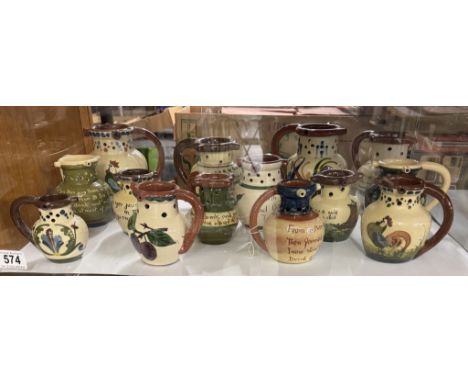 A shelf of vintage Torquay ware puzzle jugs 