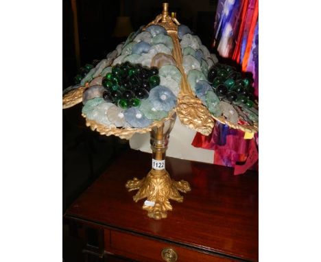 An unusual table lamp with coloured glass shade featuring grapes and flower heads. 