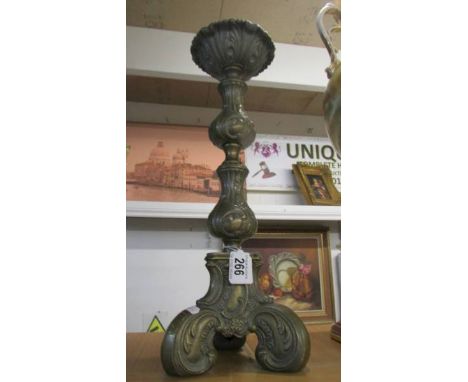 A tall ornate brass candlestick. 