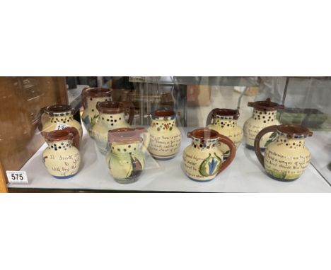 A shelf of vintage Torquay ware puzzle jugs 