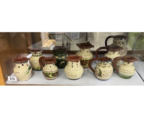 A shelf of vintage Torquay ware puzzle jugs 