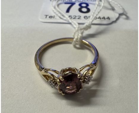 A 9ct gold ring set red stone with diamond shoulders, size R, 2.3 grams.Fully hallmarked.