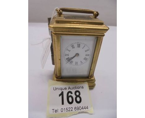 A miniature brass carriage clock.