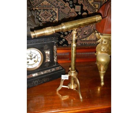 A brass telescope on tripod. 