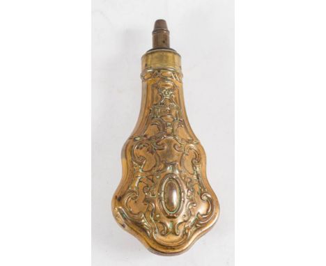 A copper and brass powder flask: with spring loaded measure over a shaped repousé decorated body, 21cm long