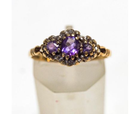 A three stone amethyst 9 carat gold ring, with single cut diamond points, finger size P, 1.7 g gross