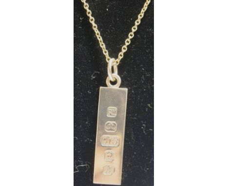 A 9 carat gold ingot pendant, London 1976, on chain, stamped '9ct' to the bolt ring, chain 50 cm long, 21 g gross