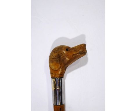 A walking stick with a carved wooden dogs head